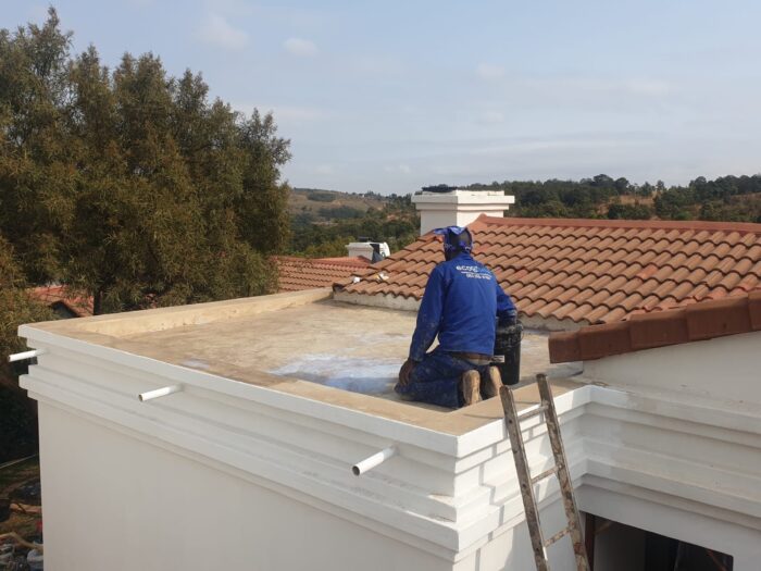 Concrete roof slab being primed for waterproofing
