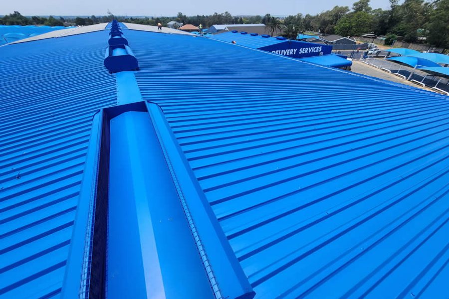Commercial IBR metal roof painted in blue on an industrial building